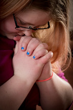 a teen girl with head bowed in prayer 