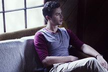 A young man sitting on a couch.