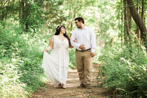 bride and groom walking on a trail in the woods 