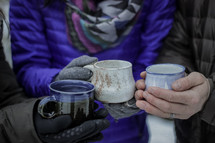 people standing outdoors in winter holding mugs 