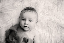 an infant on a fur rug 