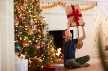 child excitedly opening a Christmas present 