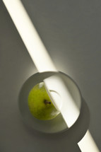 Abstract Ripe Pear With Cut from Sunrays on Table