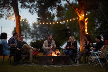 friends eating around a fire in fall 