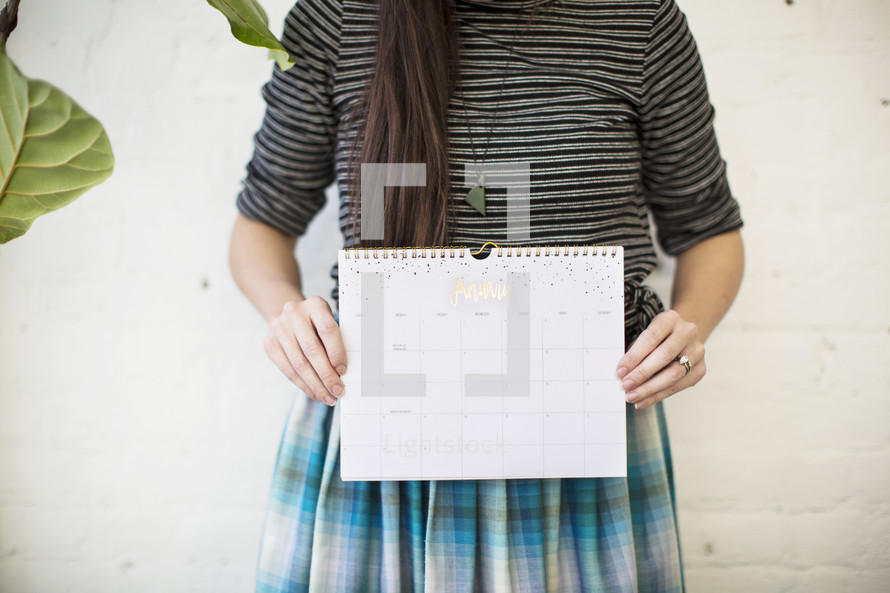 a woman holding up a calendar 