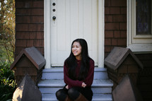 A teen girl sitting on steps. 