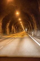 lights in a highway tunnel through a mountain 