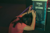 praying over a tithes sign 