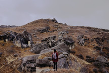 woman backpacking over a rocky terrain 