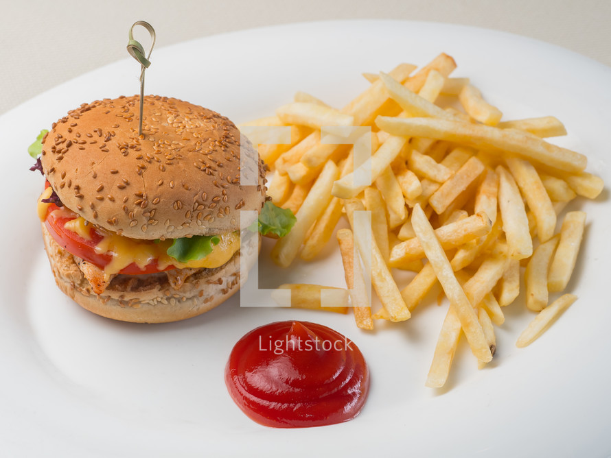 Big burger with french fries and ketchup on white plate. Fast food. Unhealthy dish.