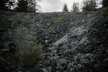 a man standing in front of a rocky slope
