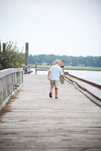 toddler boy walking on a dock 