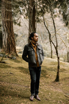 a man in a jacket standing on hillside 