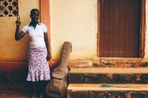 A woman standing next to a guitar case 