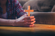a man praying holding a cross 
