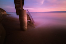 concrete steps leading down to a beach at sunset 