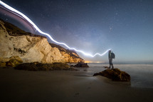 a beam of light while standing on a shore 
