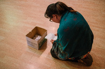a woman placing her sins in a box during a worship service 
