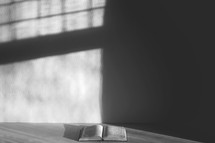 open Bible in the corner of an empty room 