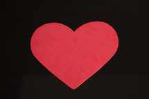 red paper heart on a black background 