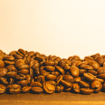 Bunch of coffee beans on a table with a light background.