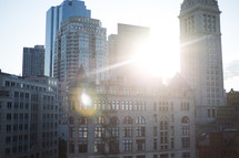 sunburst over buildings in a city 