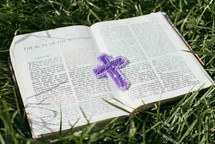 knit cross on the pages of a Bible 