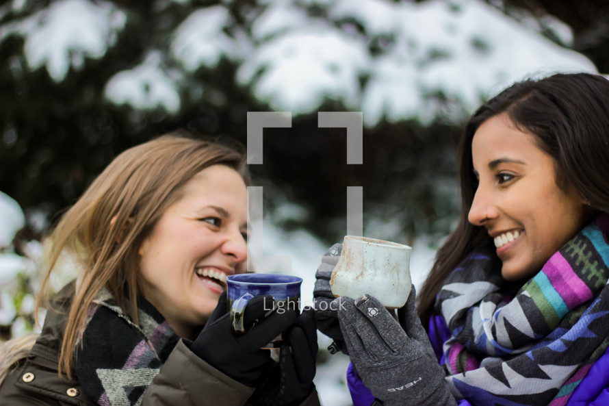 women with mugs in the snow 