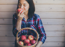 a woman holding a basket of apples 