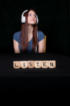 girl with headphones and word listen 