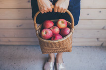 woman holding a basket of apples 