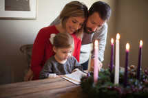 family reading a Bible near an Advent wreath 