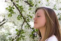 woman smelling white flowers 