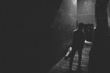 man walking back stage down a dark hallway