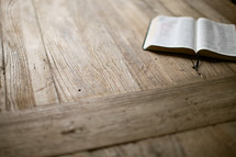 open Bible lying on a wood table