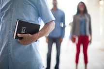 men and women standing holding Bibles 