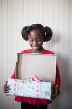 a girl child opening a Christmas present 