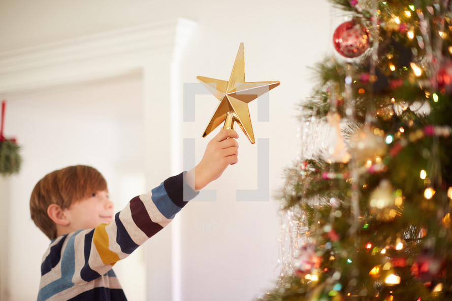 child decorating a Christmas tree