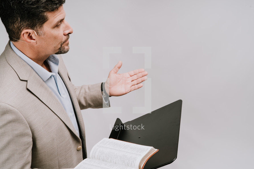 a minster preaching holding a Bible 