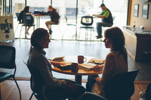 Two women in a coffee shop, visiting, studying their bibles, drinking coffee