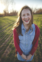 smiling teen girl with braces standing in a field