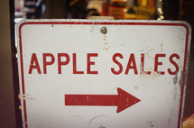 Metal "apple sales" sign in a store window.