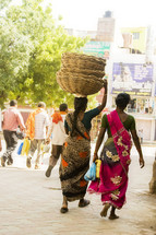 Woman in India carrying baskets on her head. 
