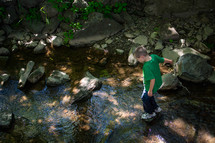 boy walking through a stream 