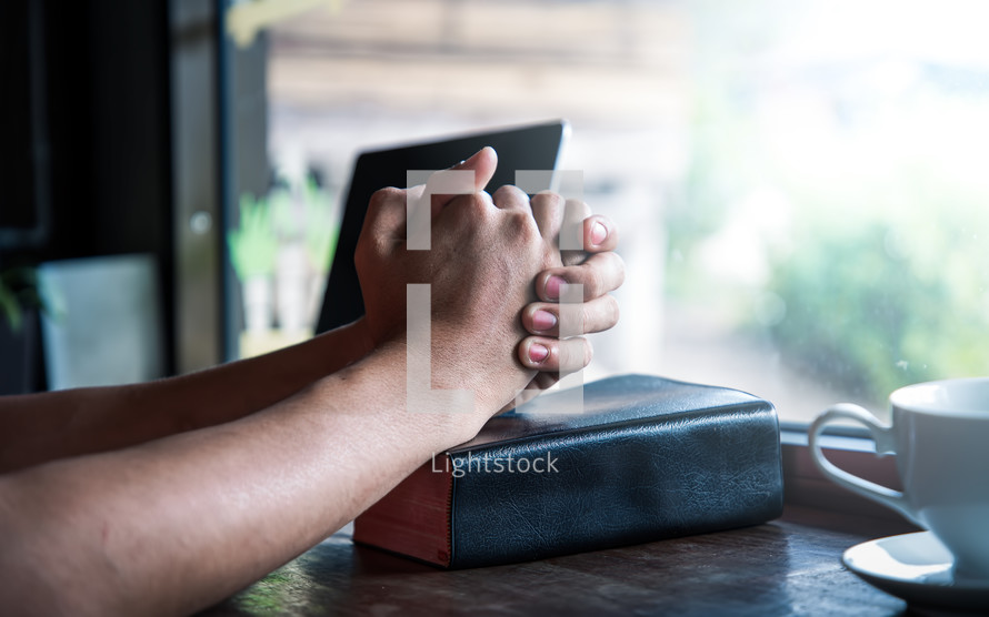 a man praying over a Bible in a window 