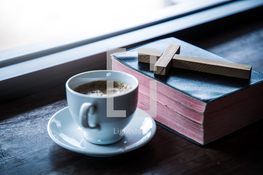 coffee cup and cross on a Bible 