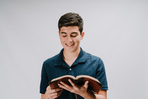 teen boy reading a Bible 