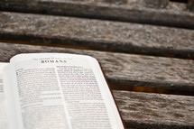 a Bible open to Romans 