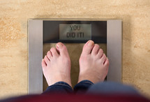 You did it - person standing on a scale 