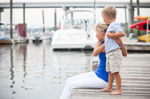 mother and son sitting on a dock 